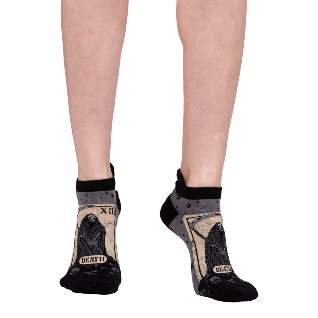 Socks with 'Death' tarot card design worn by a person on a white background