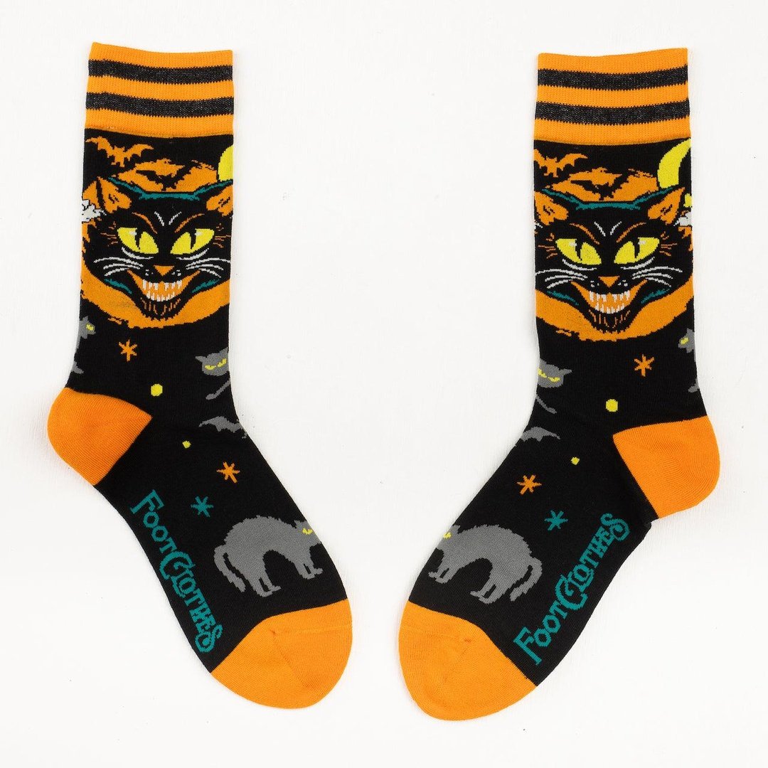 Halloween-themed socks with black cats and orange accents on a white background