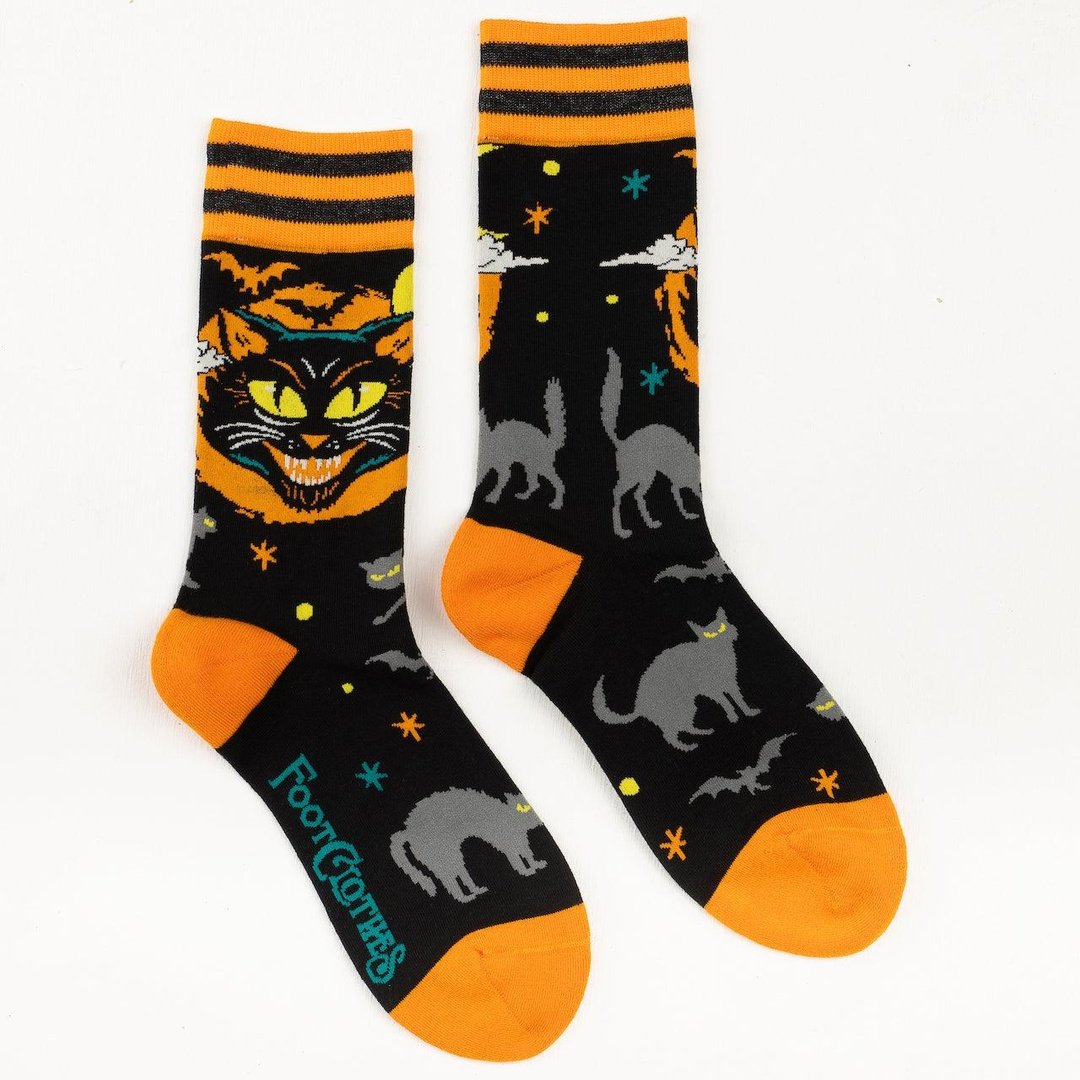 Halloween-themed socks with cats and bats on a black background, featuring orange accents.