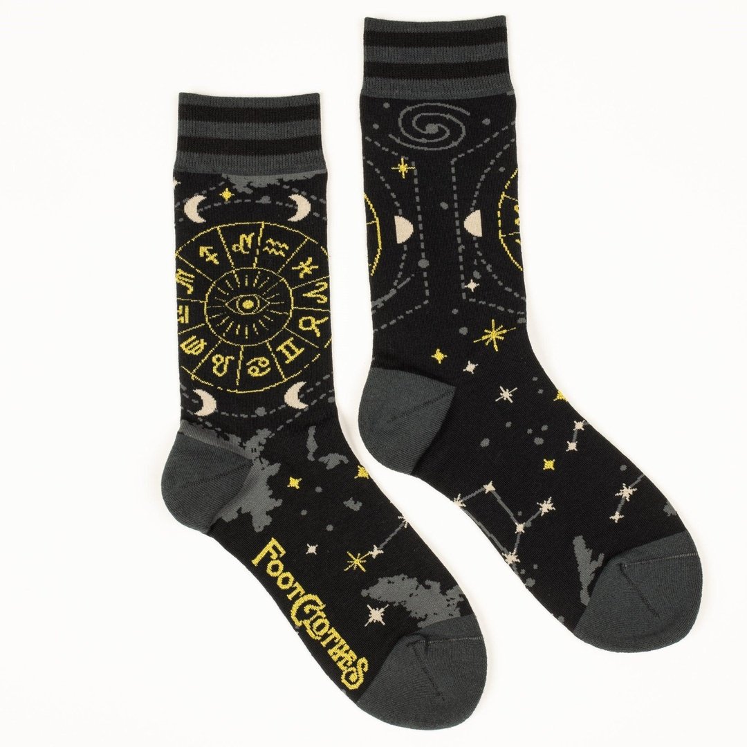 Black socks with yellow astrological design and 'Foot Clothes' branding on a white background