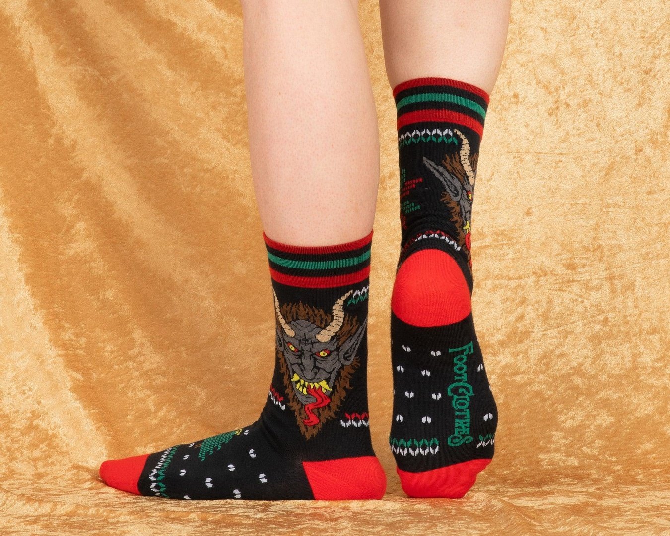 Black socks with dragon design and red accents on a beige background
