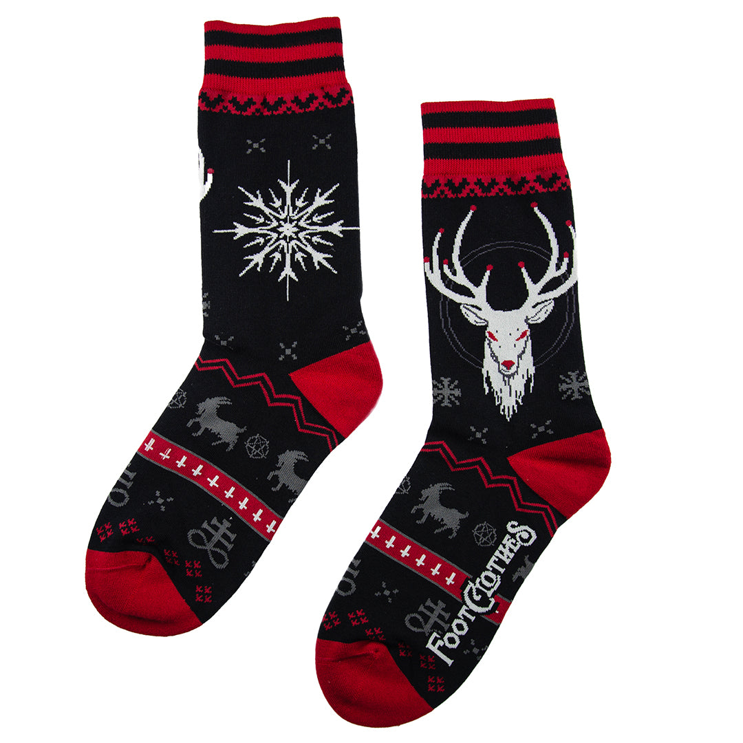 Two black socks with red accents featuring deer and snowflake designs on a white background.