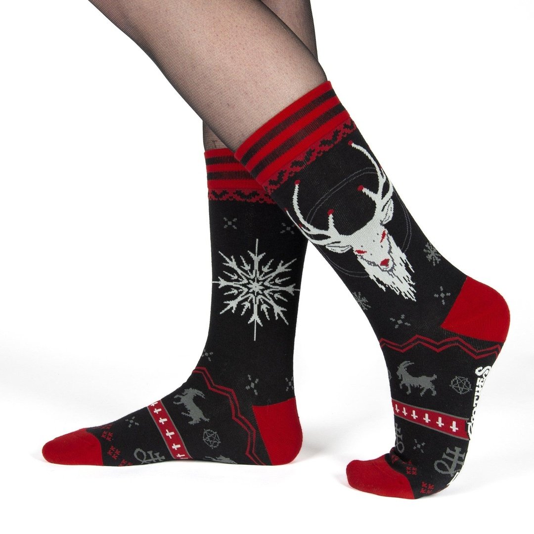 Black socks with red accents featuring deer and snowflake patterns on a white background