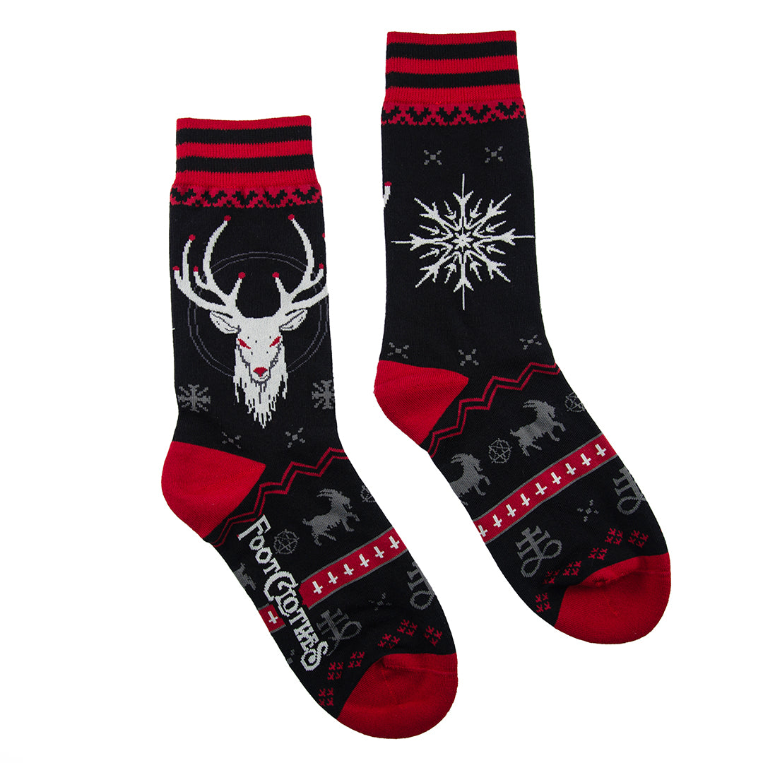 Two socks with deer and snowflake designs on a black background