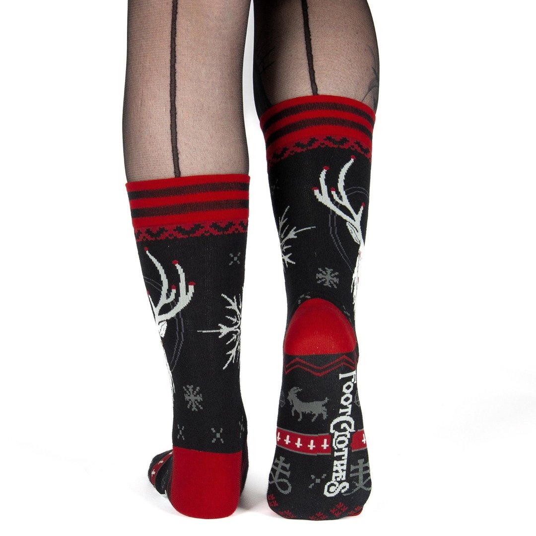 Black socks with red and white patterns worn with sheer tights on a white background