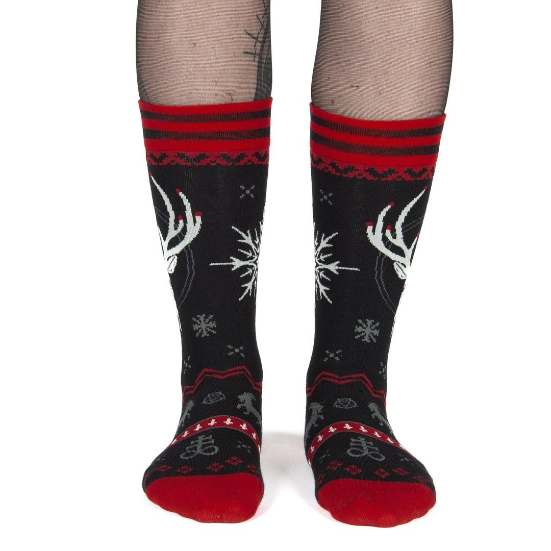 Black socks with red and white patterns worn by a person on a white background