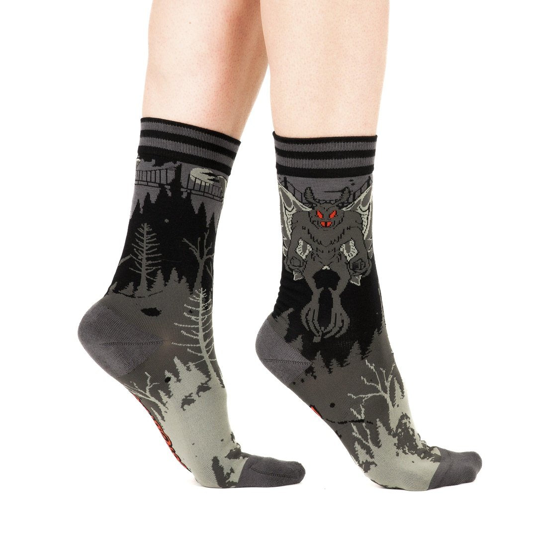 Pair of socks with nature and creature design on a white background