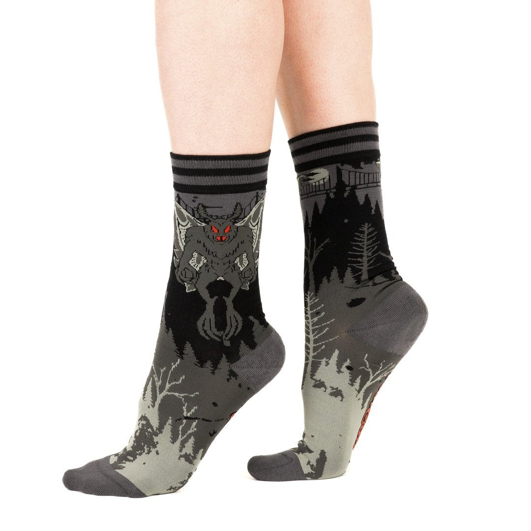 Gray socks with wolf design worn by a person on a white background