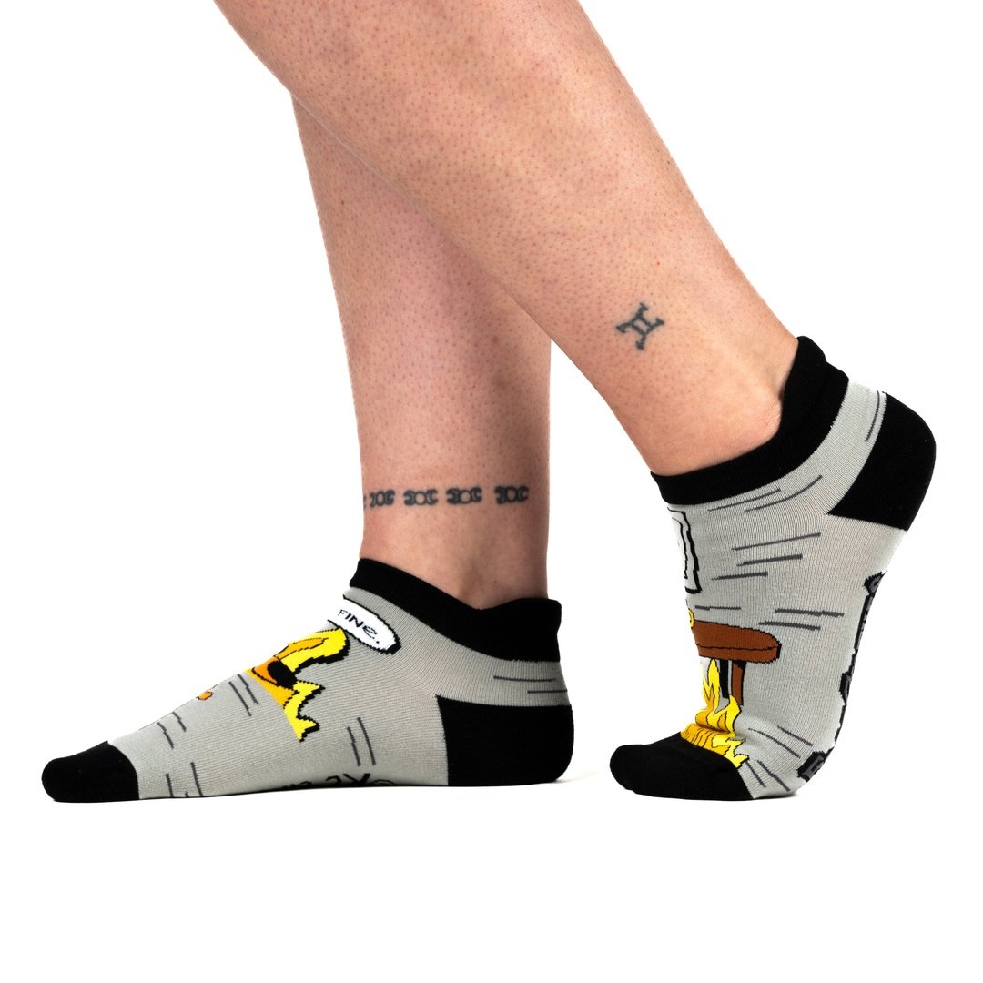 Person wearing socks with cartoon character design on a white background