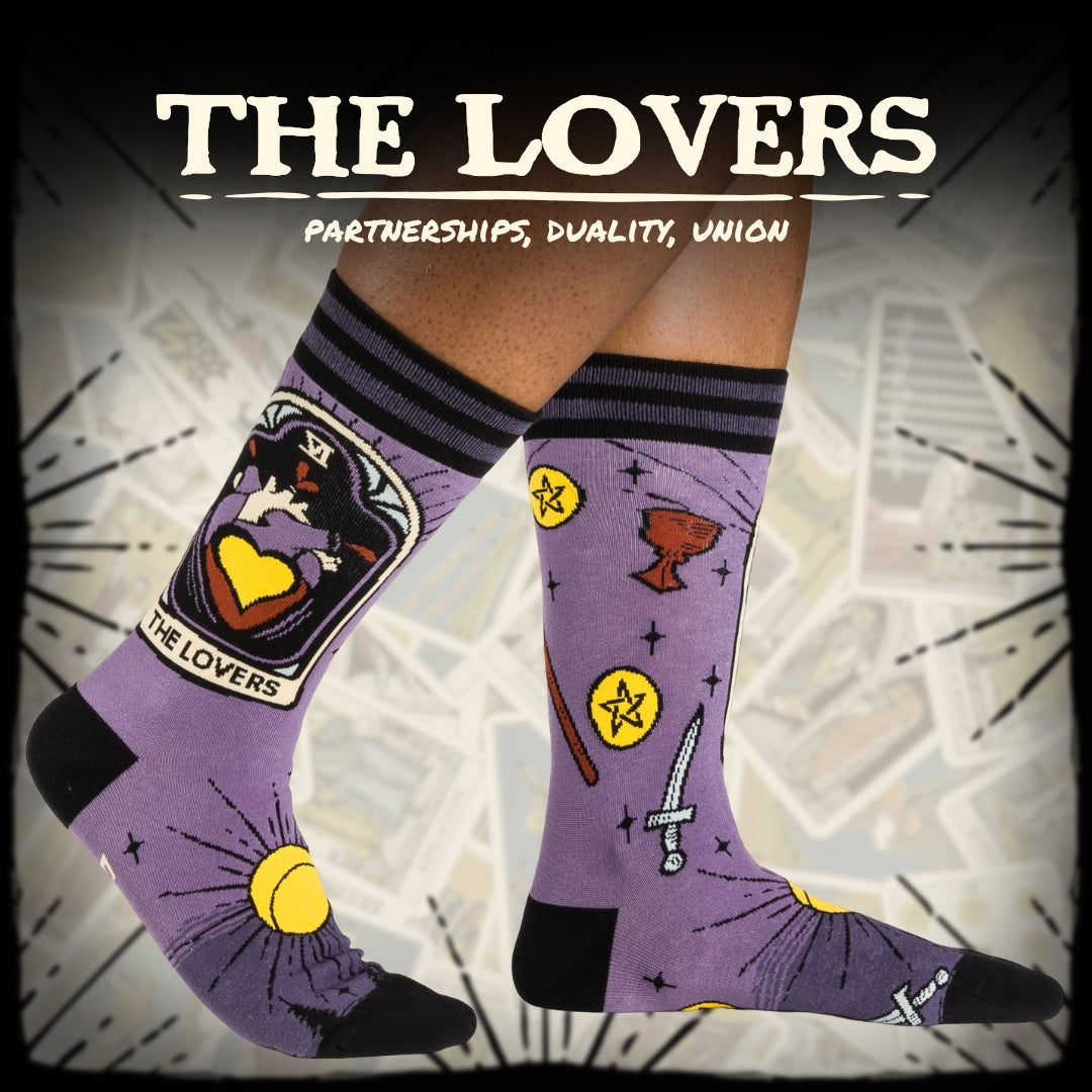 Purple socks with tarot card design and text 'The Lovers' on a geometric patterned background.