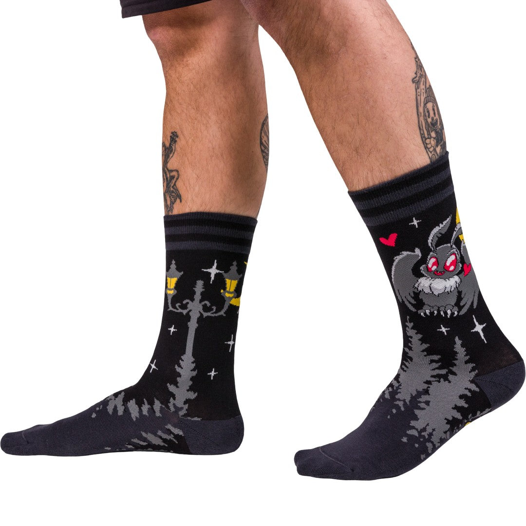 Black socks with cartoon character design worn by a person on a white background