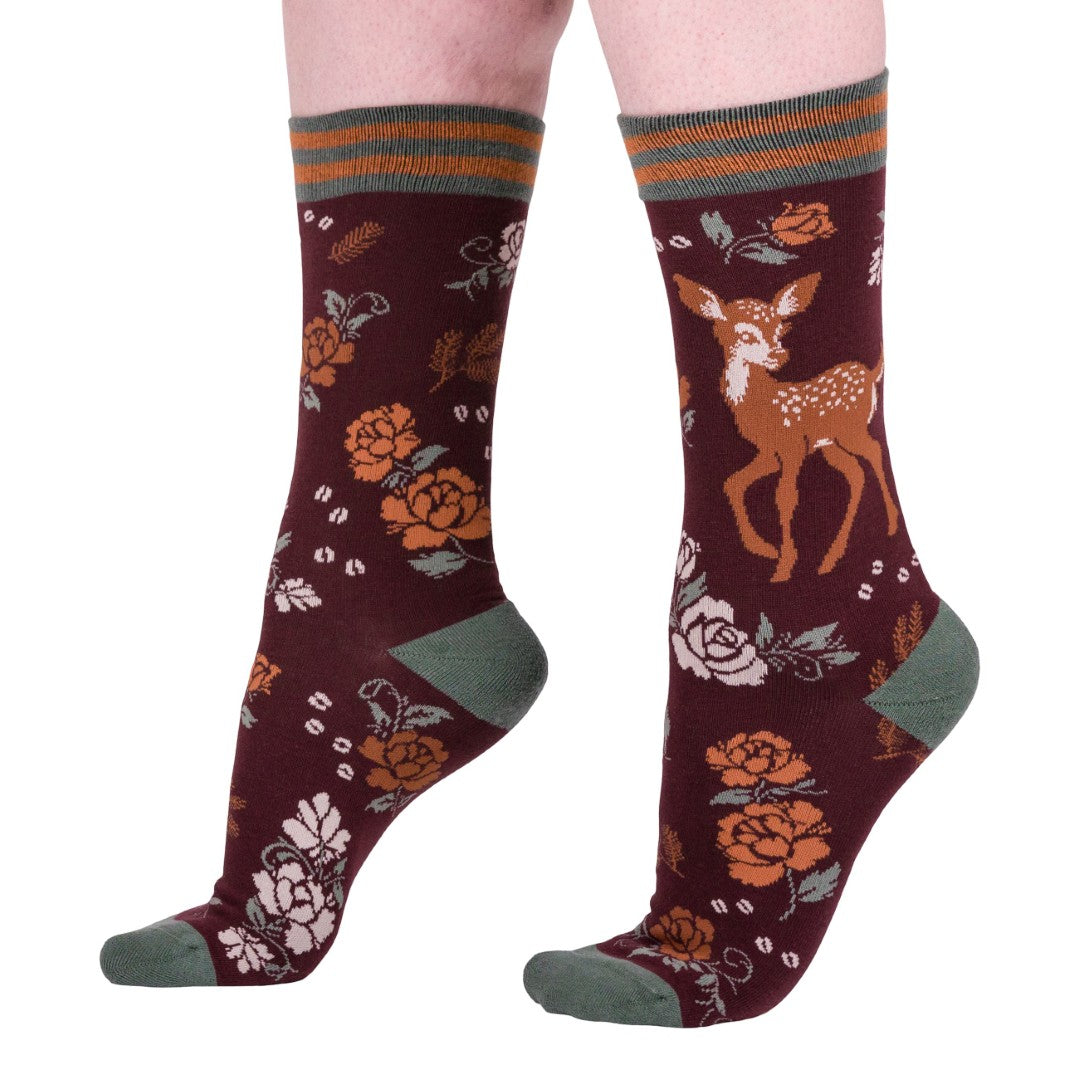 Maroon socks with deer and floral patterns on a white background