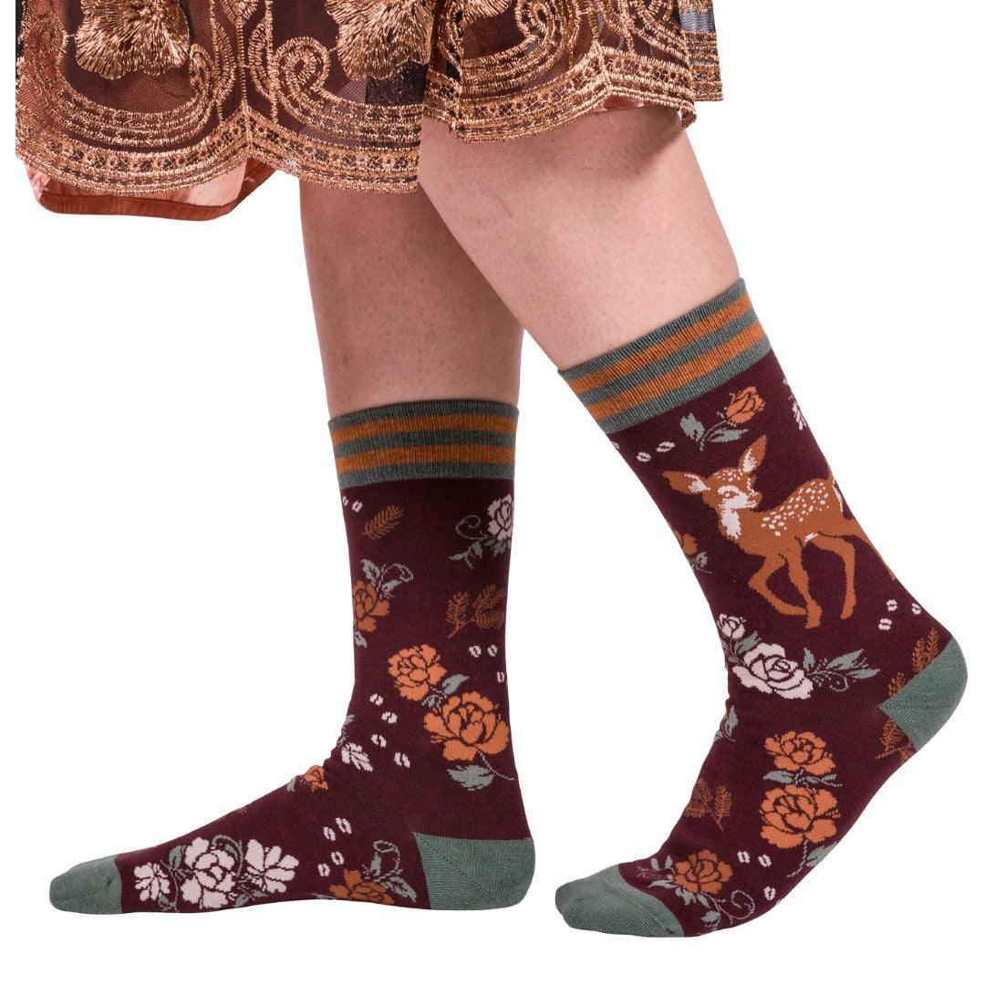 Patterned socks with deer design worn by a person on a white background