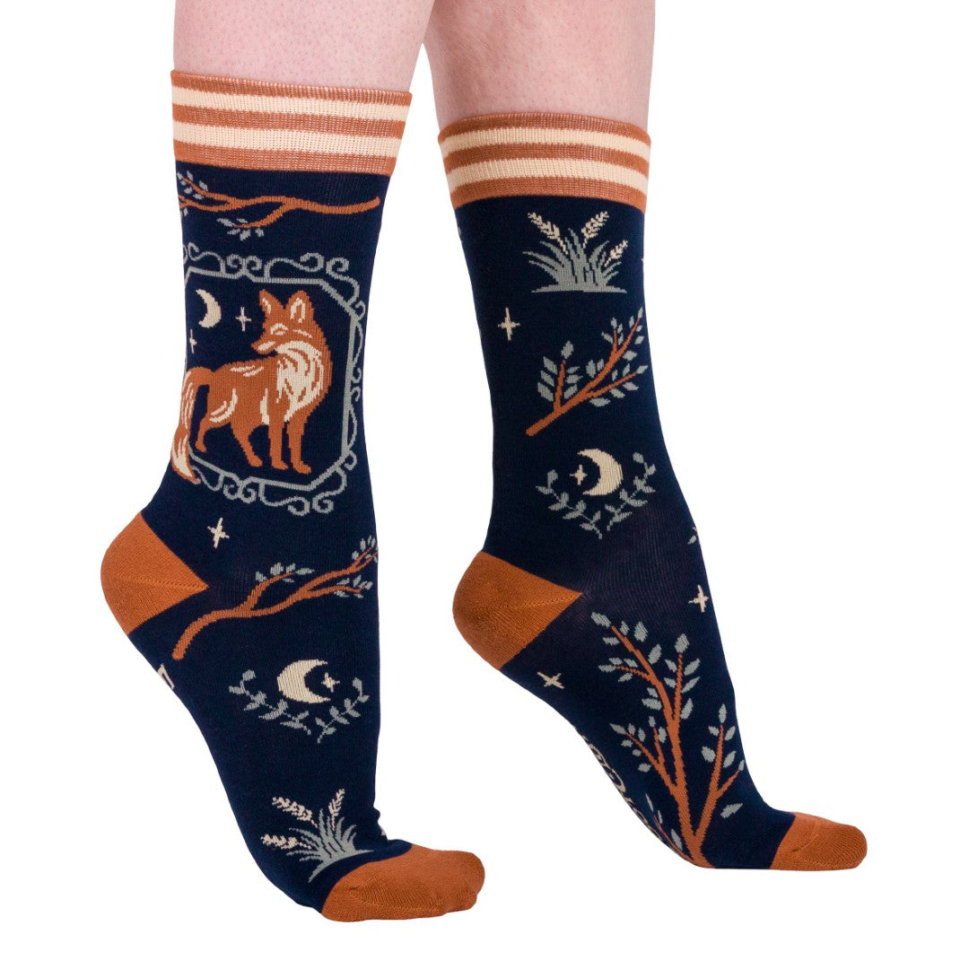 Navy socks with fox and nature-themed design worn by a person on a white background