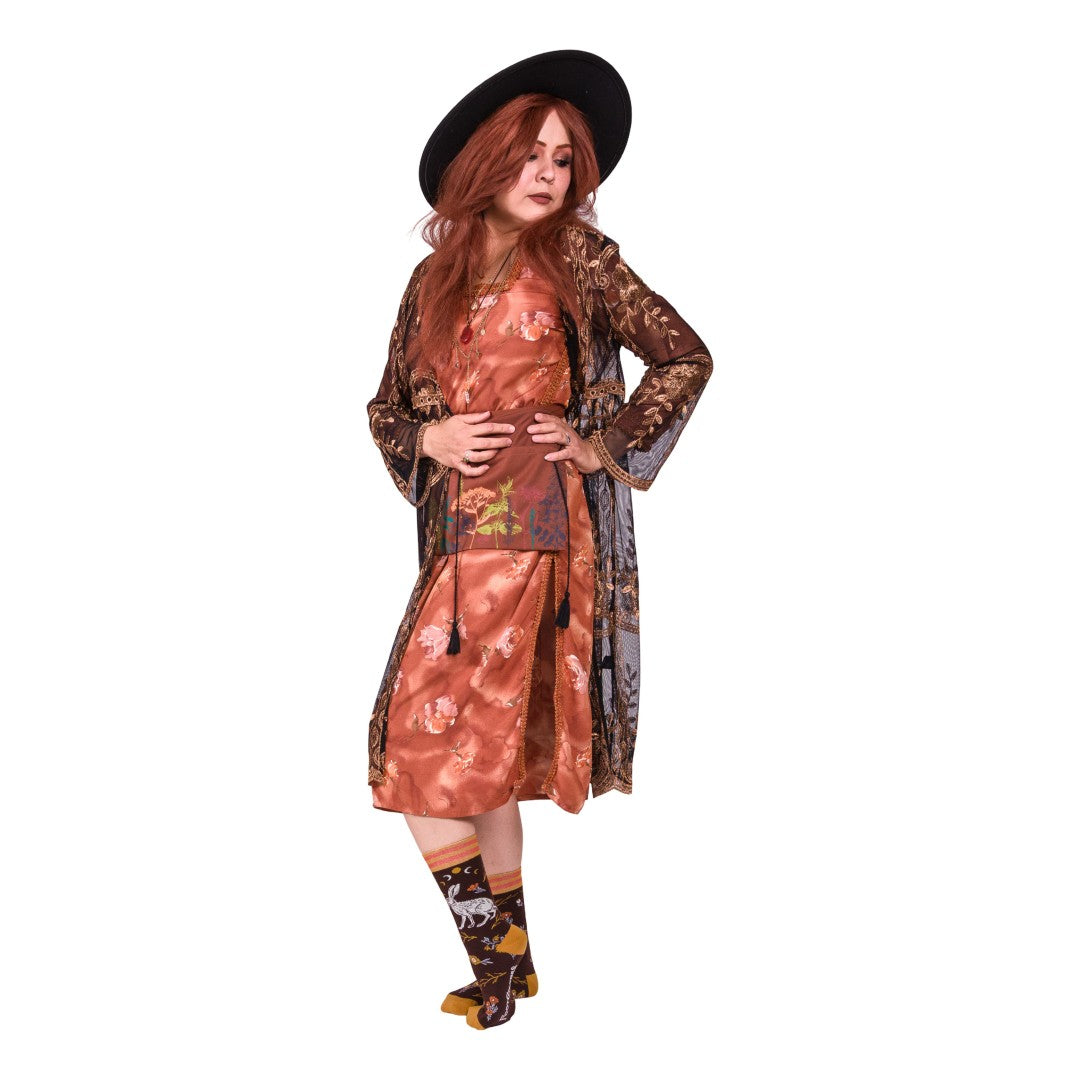 Woman wearing a patterned dress, hat, and socks on a white background