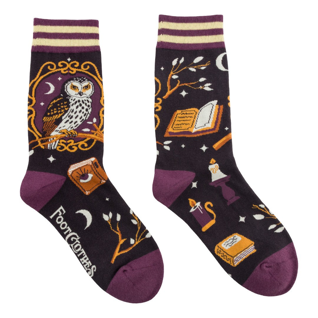 Pair of socks with owl and book design on a dark background
