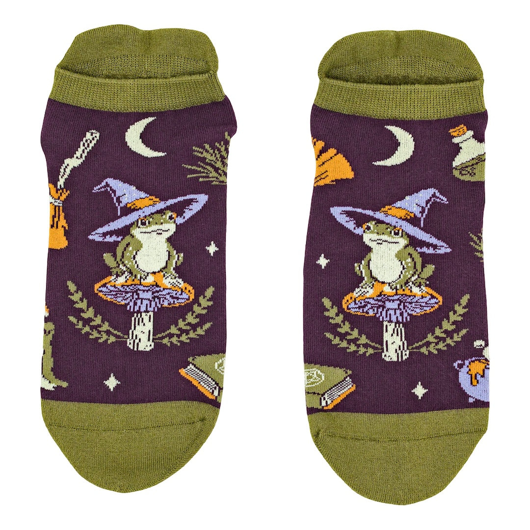 Pair of socks with frog wearing a witch hat design on a purple background
