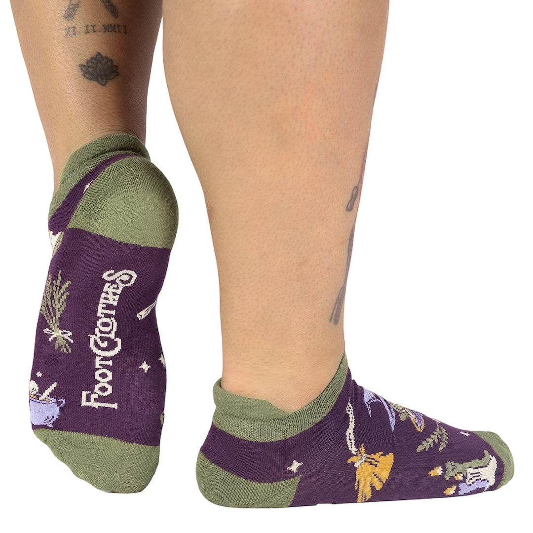 Purple socks with green accents worn by a person on a white background