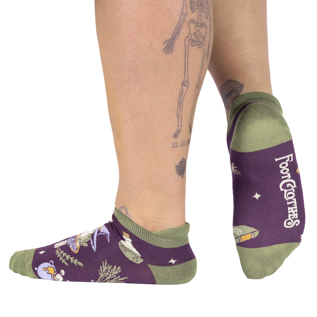 Purple socks with green accents worn by a person on a white background