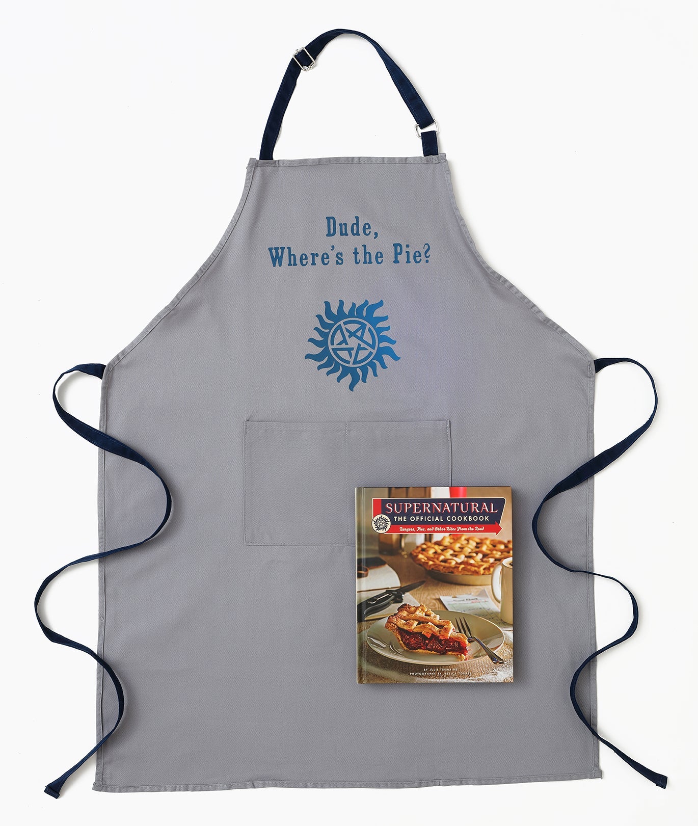 Gray apron with 'Dude, Where's the Pie?' text and Supernatural book cover on a white background