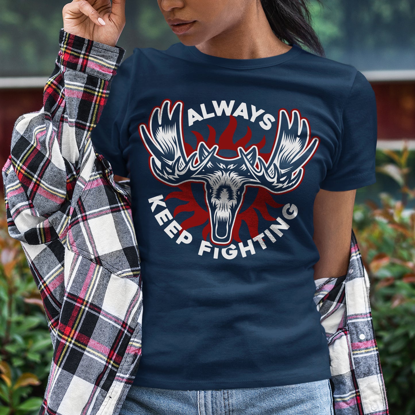 Person wearing a navy blue t-shirt with a graphic design and text 'Always Keep Fighting' outdoors.