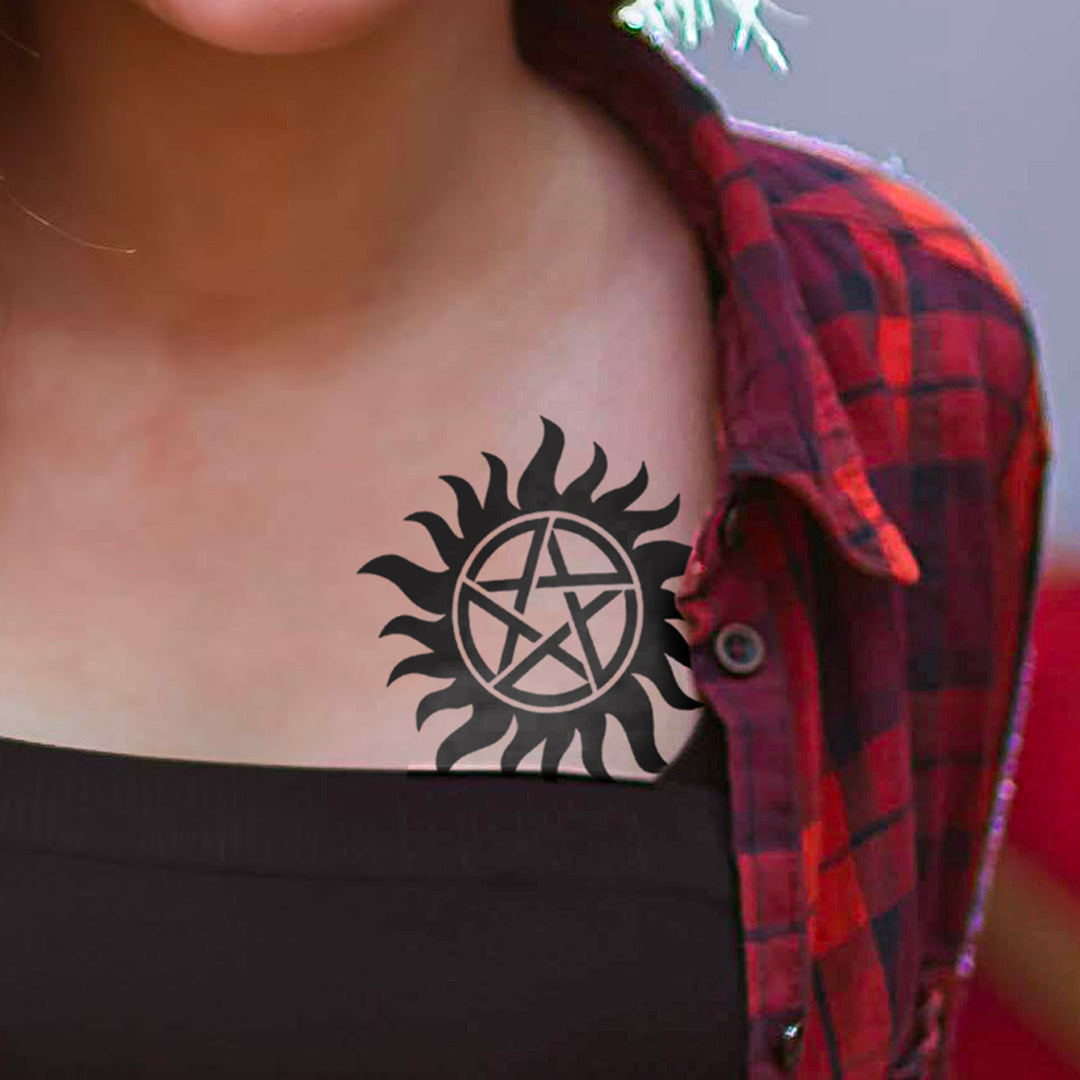 A model in a black tank top and red/blue/black flannel top with a black anti-possession temporary tattoo on her chest