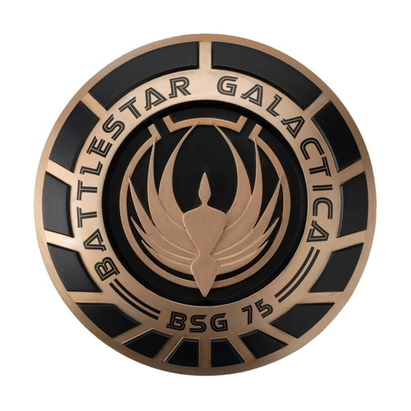 A bronze and black, round plaque, bearing the seal of the Battlestar Galactica.