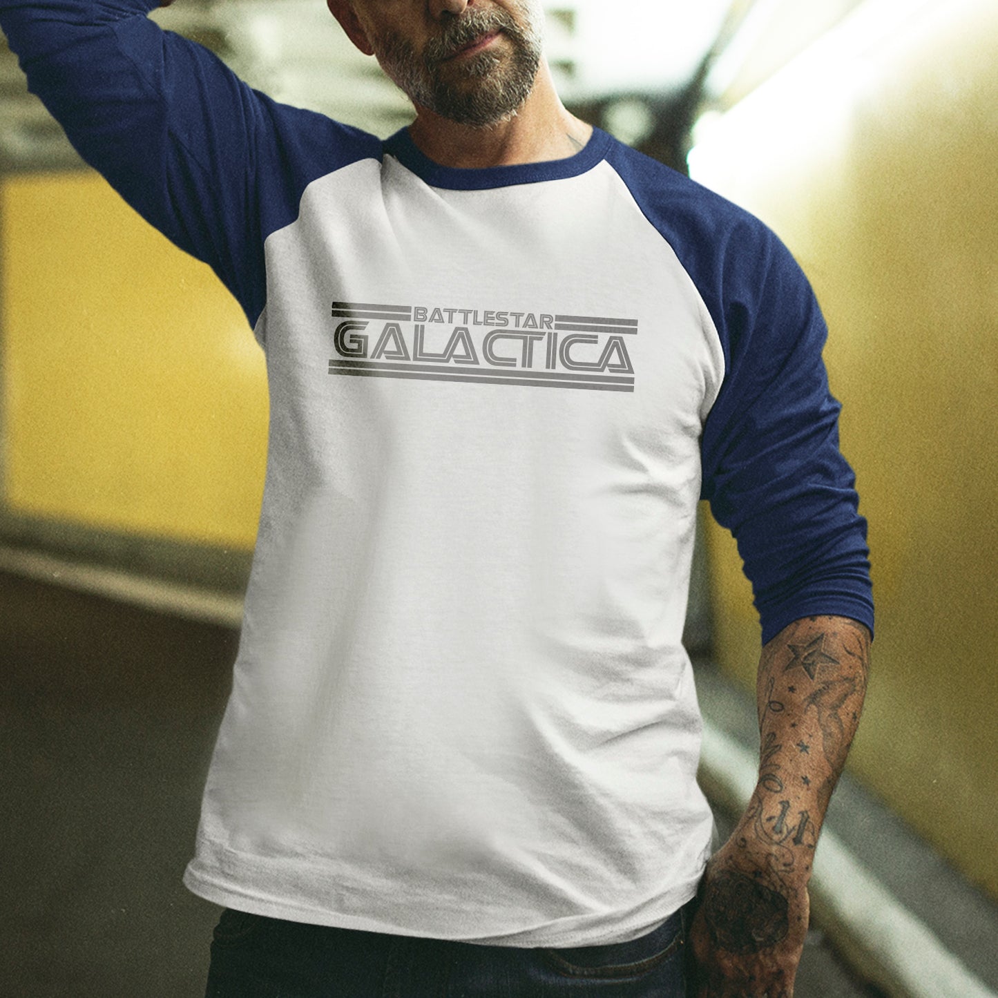 Person wearing a 'Battlestar Galactica' baseball shirt with blue sleeves.