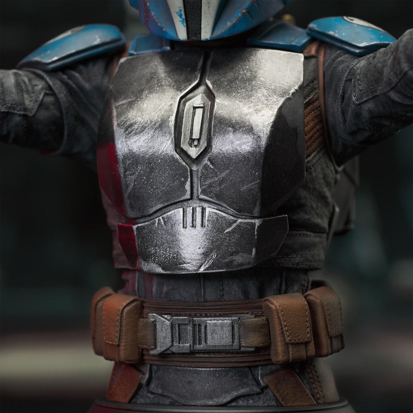 A resin bust depicting Bo-Katan Kryze in her Nite Owl armor, holding blasters in each outstretched hand. In the background is a hangar bay.