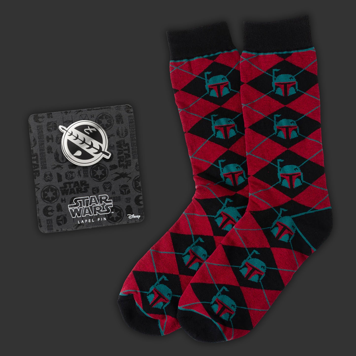 Red and black patterned socks with Mandalorian pattern, next to a Star Wars caped pin on a dark background