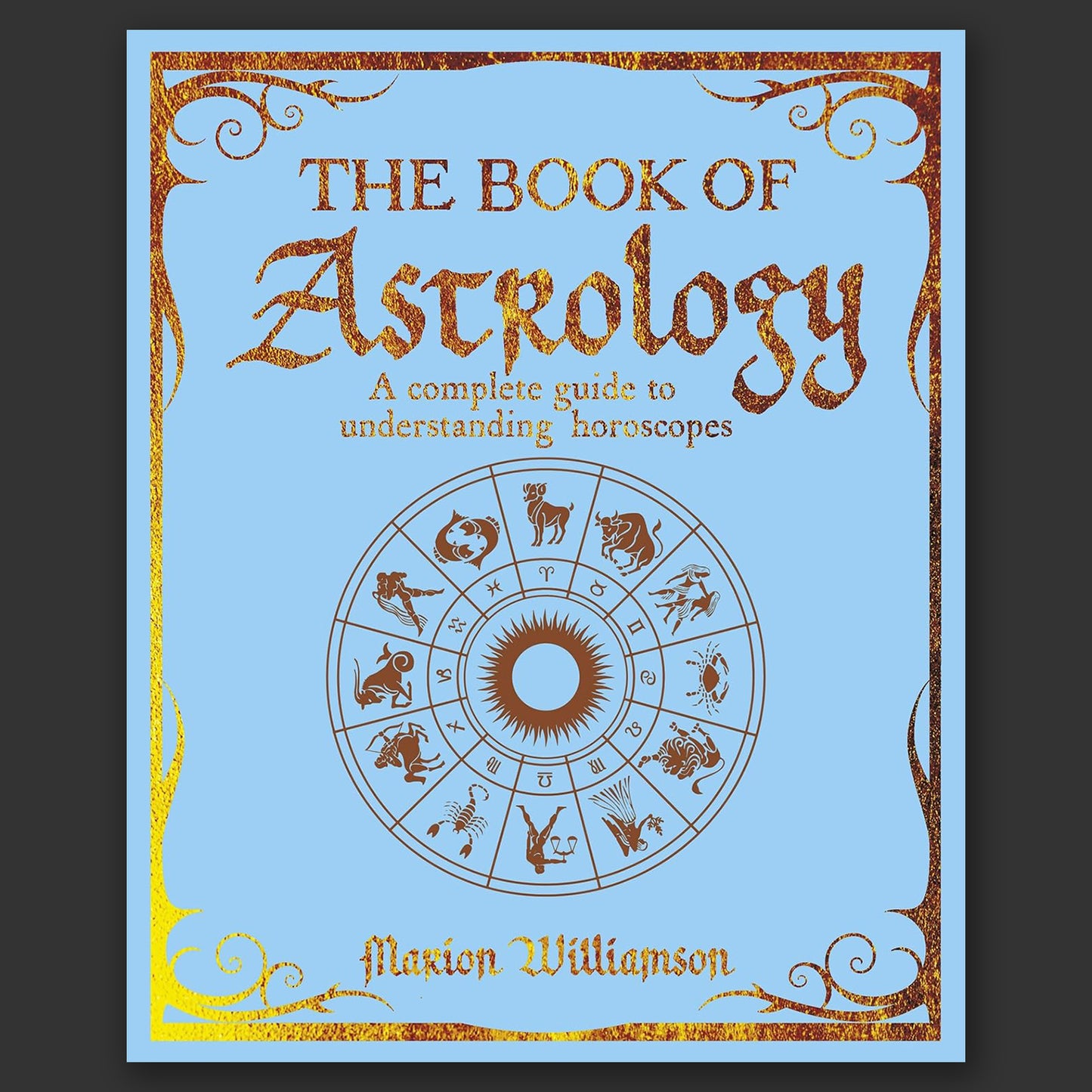 A light blue book on a grey background. Gold text says "The book of astrology. A complete guide to understanding horoscopes." Under the title is a depiction of the 12 zodiac signs and their symbols in a wheel.