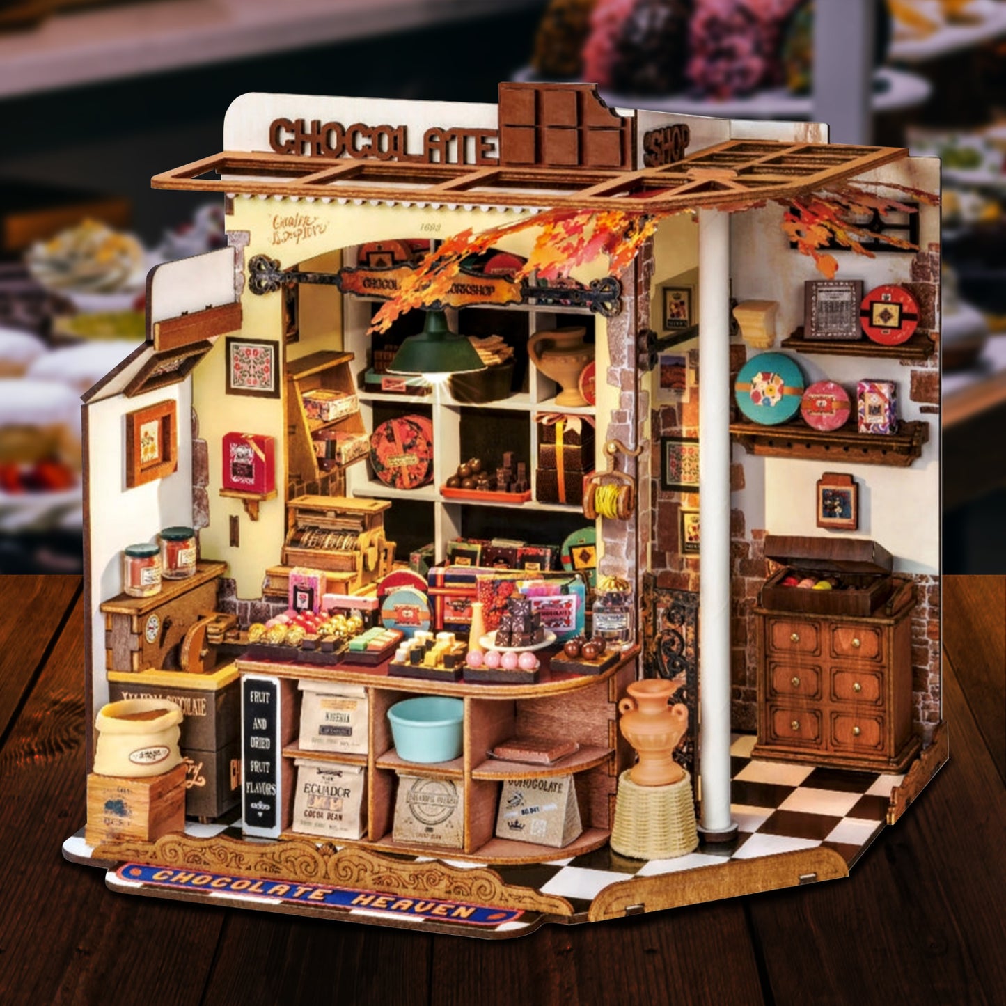 A miniature model kit depicting a chocolate shop, filled with sweets. In the background is a sweet shop.