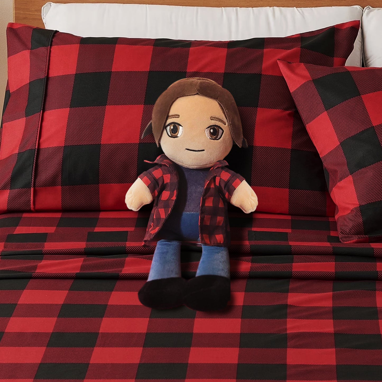 Plush toy with a red and black checkered outfit on a bed with matching bedding.