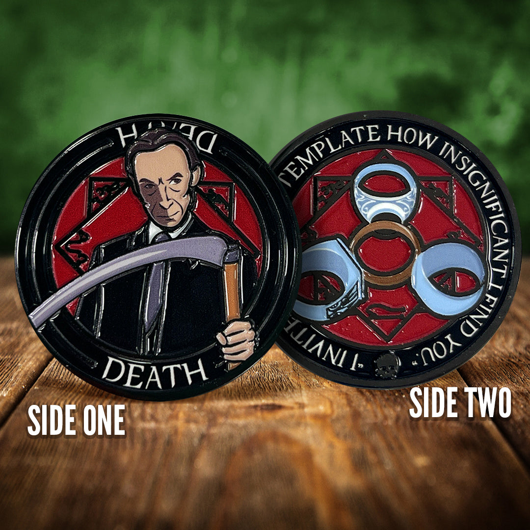 Two challenge coins side by side on a wooden table. The left coin depicts Death from the TV series Supernatural. The right coin has a symbol on a red background 