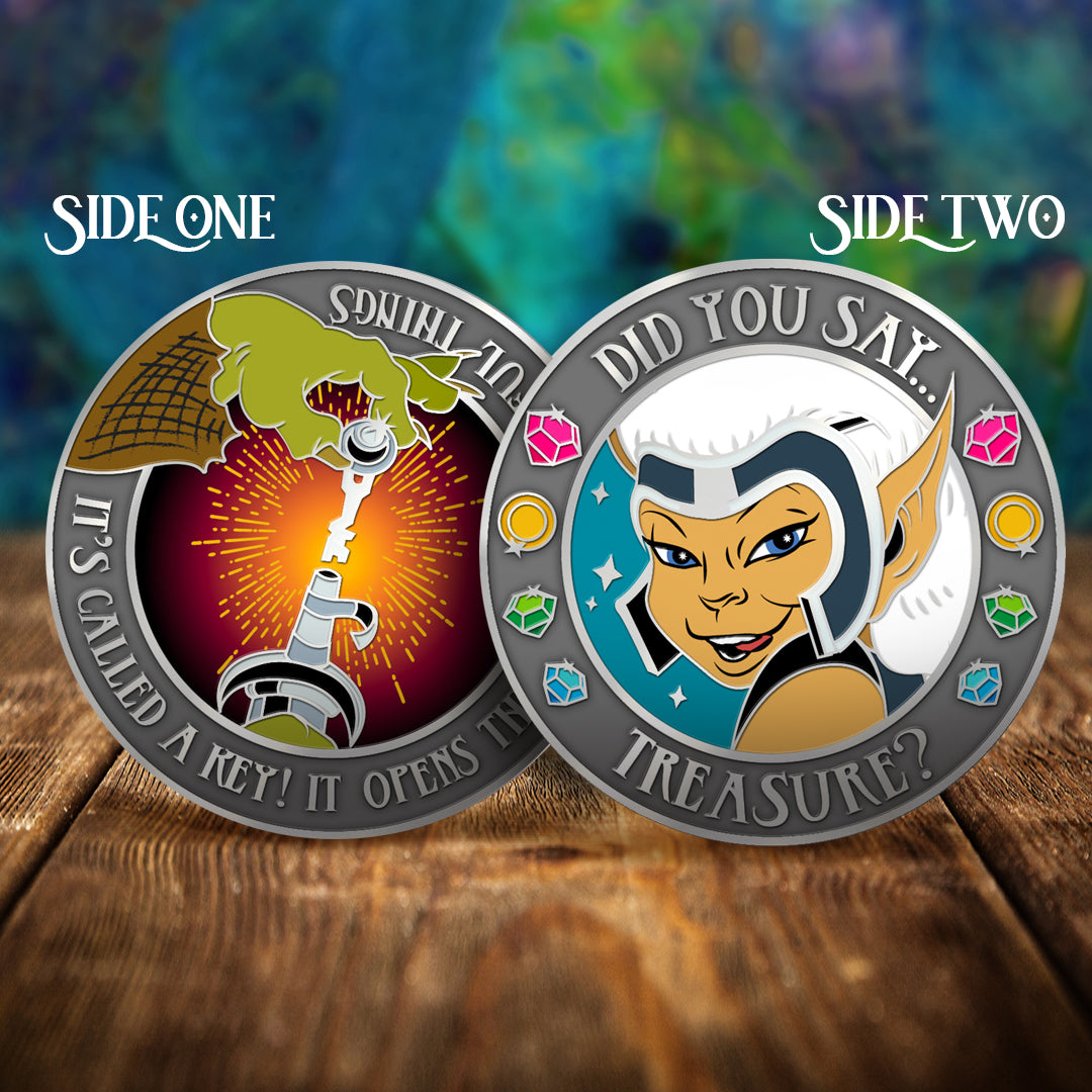 Two challenge coins side by side on a wooden table, with a swirling green and blue pattern in the background. The left coin shows a green hand holding a silver key. Around the edge is text saying "it's called a key! It opens things, wonderful things." The right coin shows the character Skywise against a blue background. Around the edge is text saying "did you say treasure?" with colored jewels at the sides.