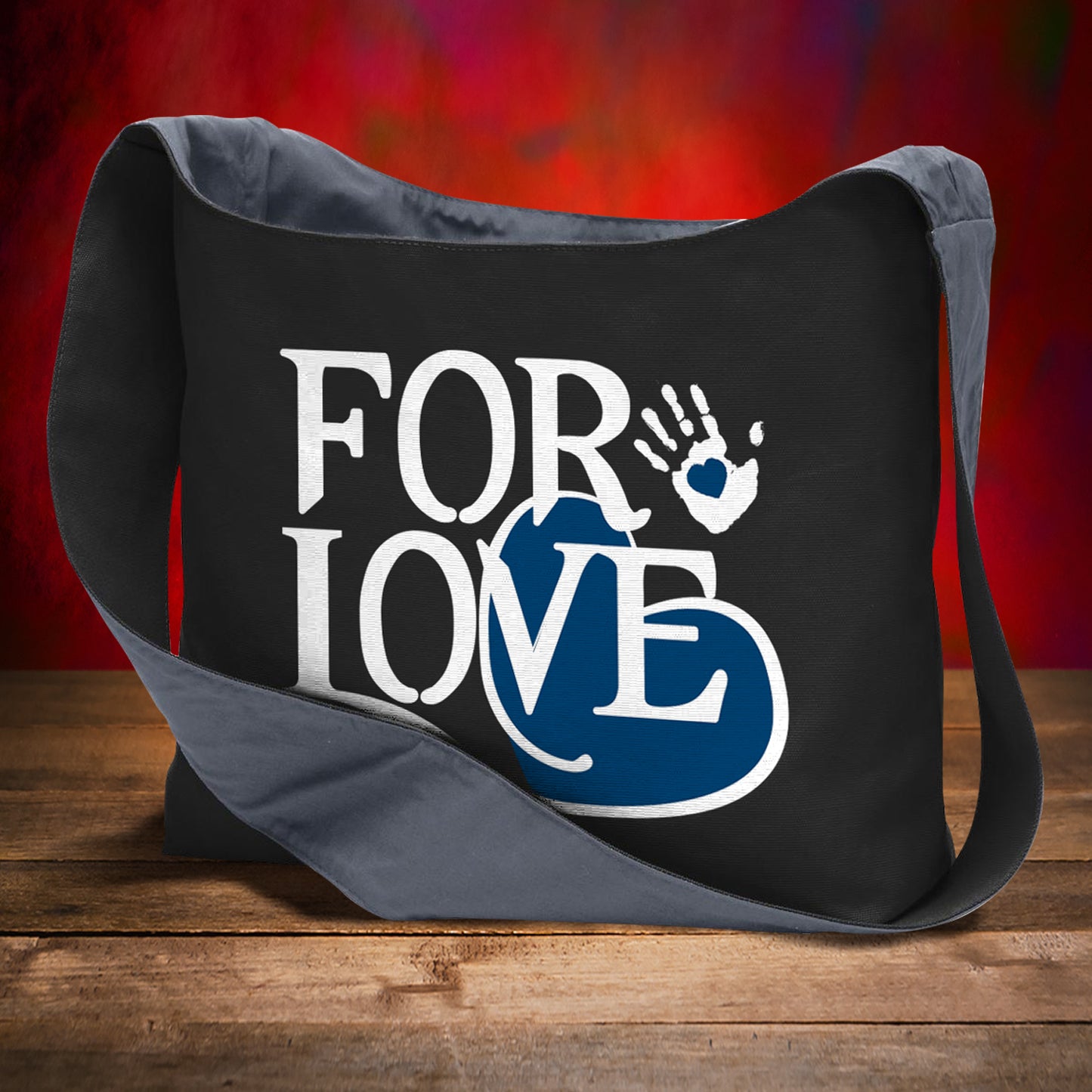 Black bag with 'FOR LOVE' text and handprint design on a wooden surface with red background