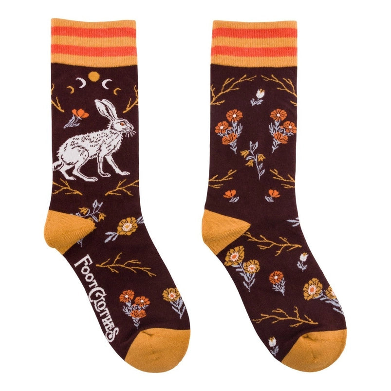 A pair of crew length brown sock. The socks feature a pattern of red and yellow flowers, with a white hare on the side.