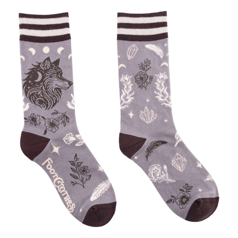 A pair of crew length grey socks. The socks feature a pattern of white and black crystals and flowers, with a black wolf on the side.