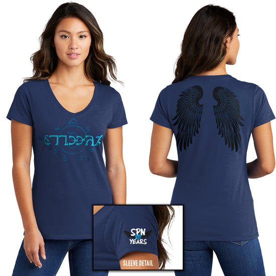 Front and back images of a model wearing a blue V-neck shirt. The front of the shirt has light blue runes, which spell out the word "funnier" in the angelic language Enochian. On the left sleeve is a pair of black wings with white and blue text that says "SPN 20 years." The back of the shirt has a pair of large black angel wings.