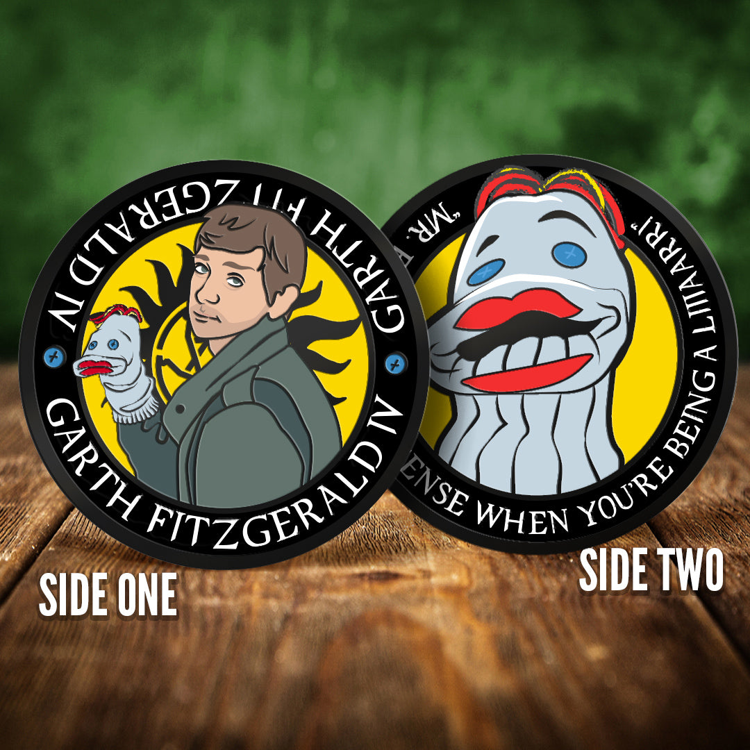 Two coins with illustrations of a man and a sock puppet, labeled 'Side One' and 'Side Two', on a wooden surface with a green background.