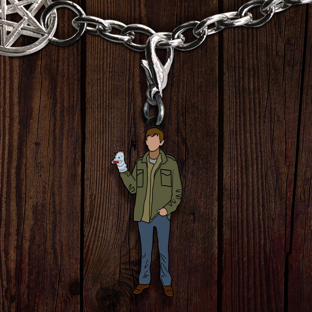 A metal charm on a bracelet, depicting the Supernatural character Garth with Mr Fizzles