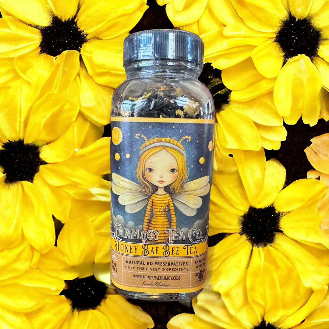 A bottle of Honey Bae Bee Tea, centered against a background of bright yellow flowers with dark centers.