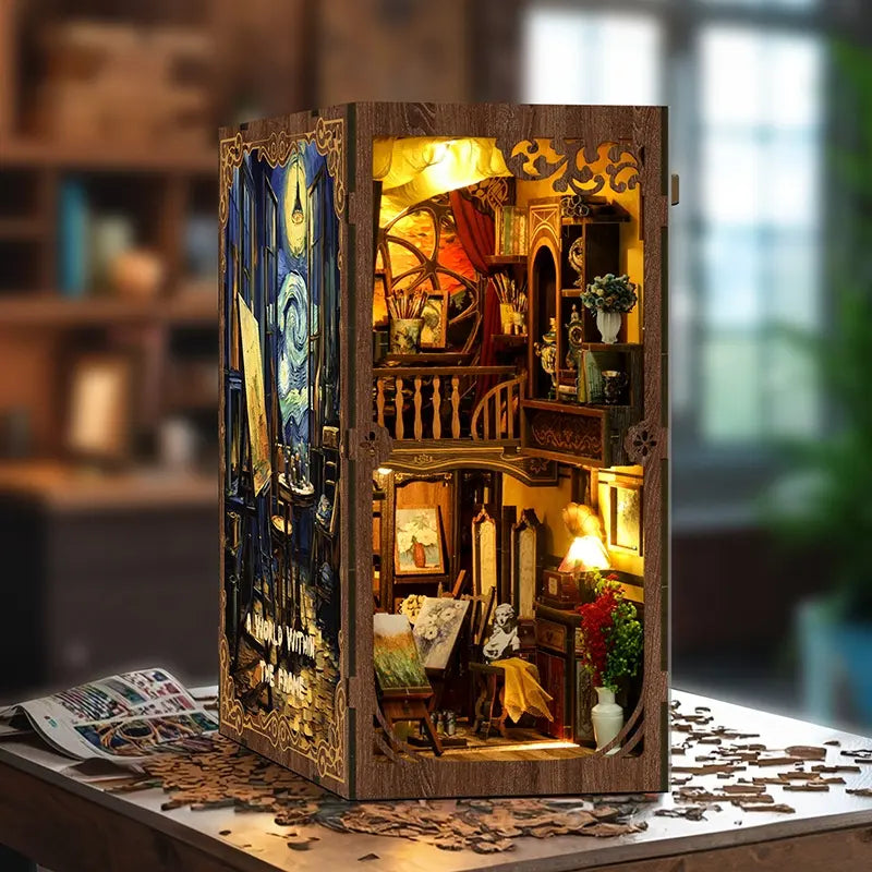 Close up of a wooden book nook light, adepicting  small house filled with classic works of art. Some pieces are paintings on easels, some are sculptures on tables. Among the artworks are lamps, and vases filled with colorful flowers.