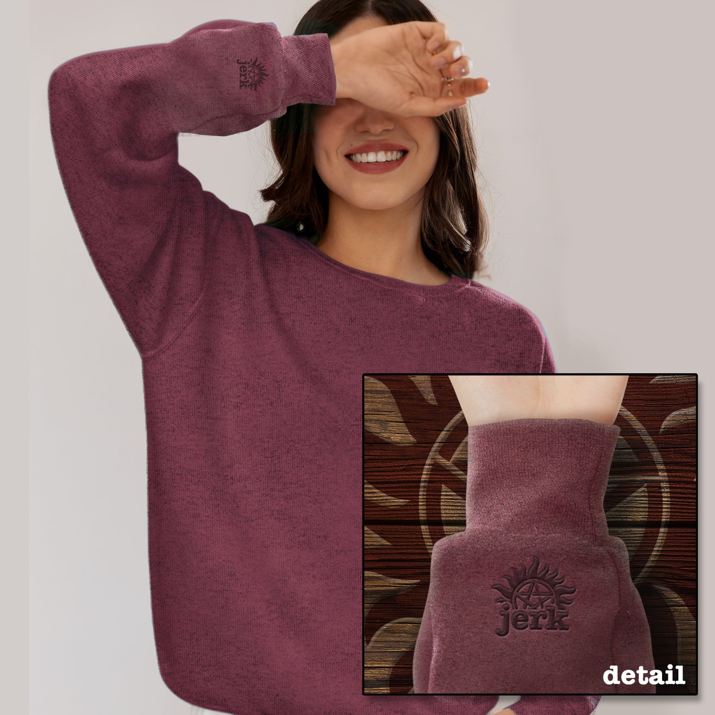 A model wearing a maroon sweatshirt. An inset image shows the cuff which features an embroidered anti-possession symbol with "jerk" underneath