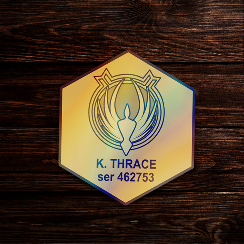 A hexagonal sticker on a wooden table, depicting the dogtag of the character Kara Thrace from the  TV series Battlestar Galactica