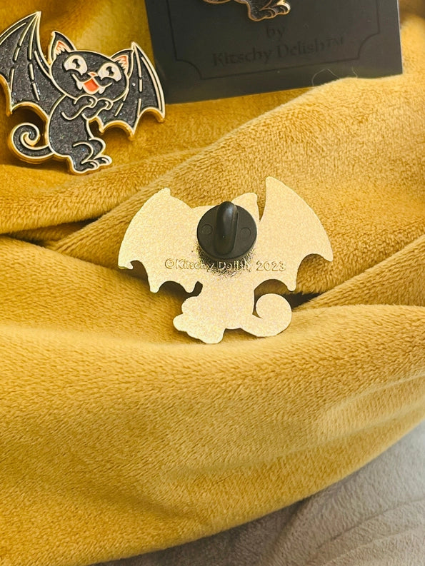Bat-shaped pins on a yellow fabric background