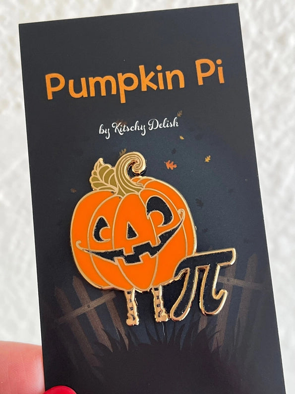 An enamel pin depicting a jack-o-lantern next to a Pi symbol