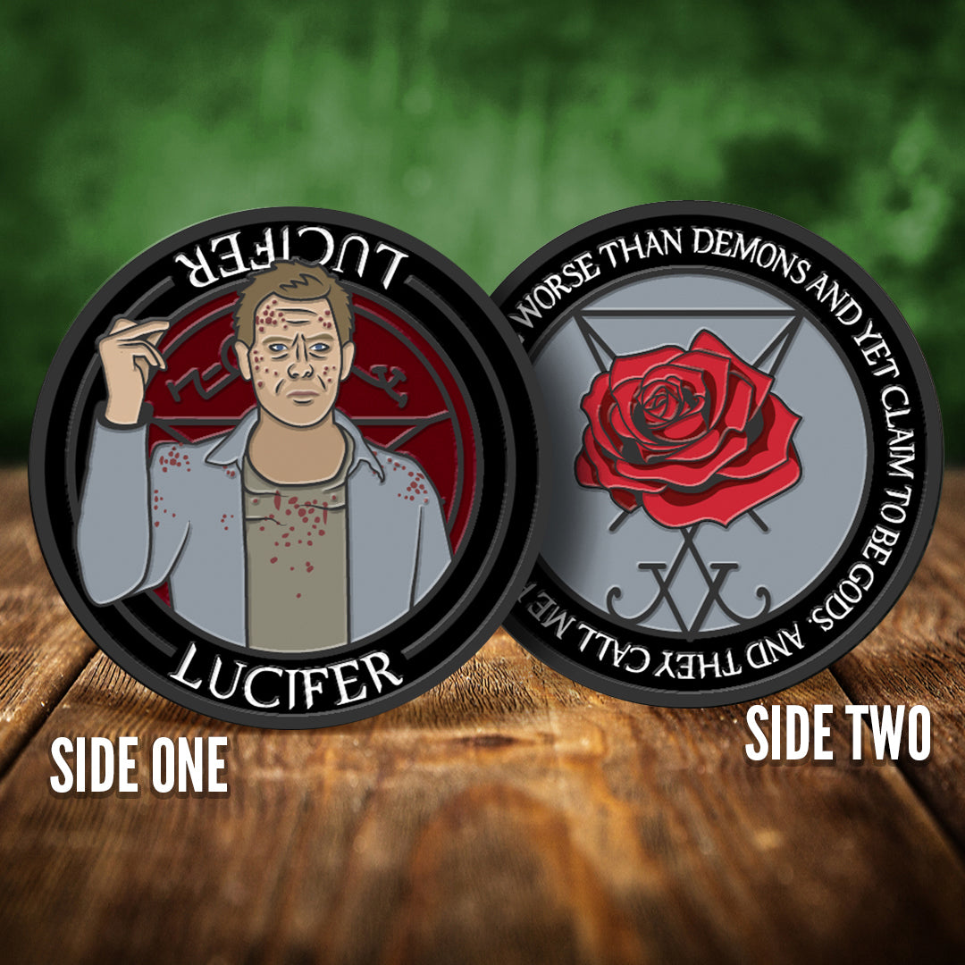 Front and back images of a challenge coin, side by side, on a wood table. The front depicts a drawing of Lucifer, spattered with blood. Behind him is a red devil's trap symbol. The back of the coin depicts a red rose against a grey background. White text around the edge says "You're worse than demons and yet you claim to be Gods. And they call me prideful."