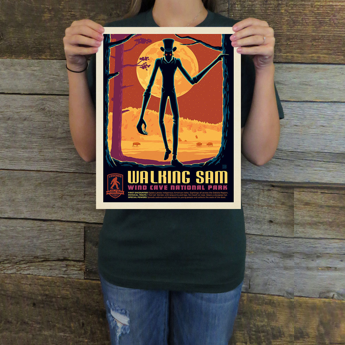 Person holding a 'Walking Sam' poster against a wooden background