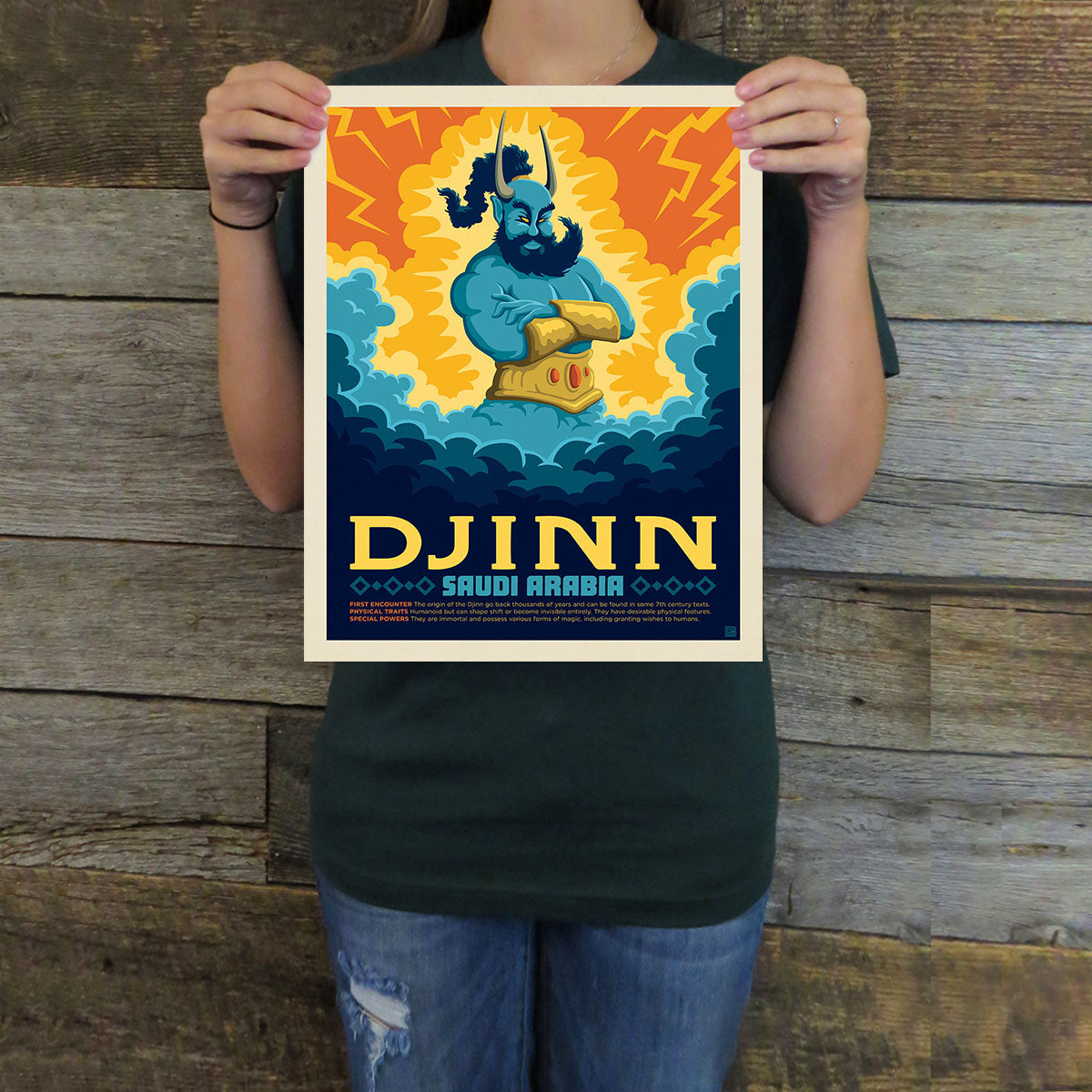 Person holding a poster of a djinn with a colorful design against a wooden background